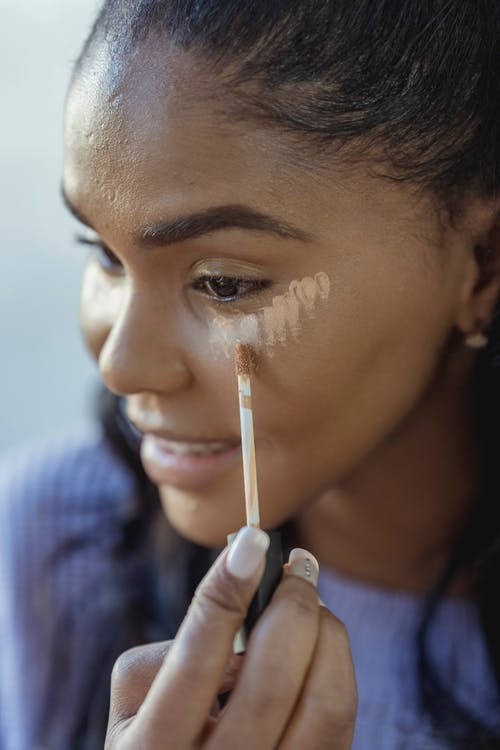 A Woman Applying Concealer Under the Eyes