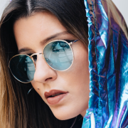 a woman in a shiny blue hoodie and sunglasses